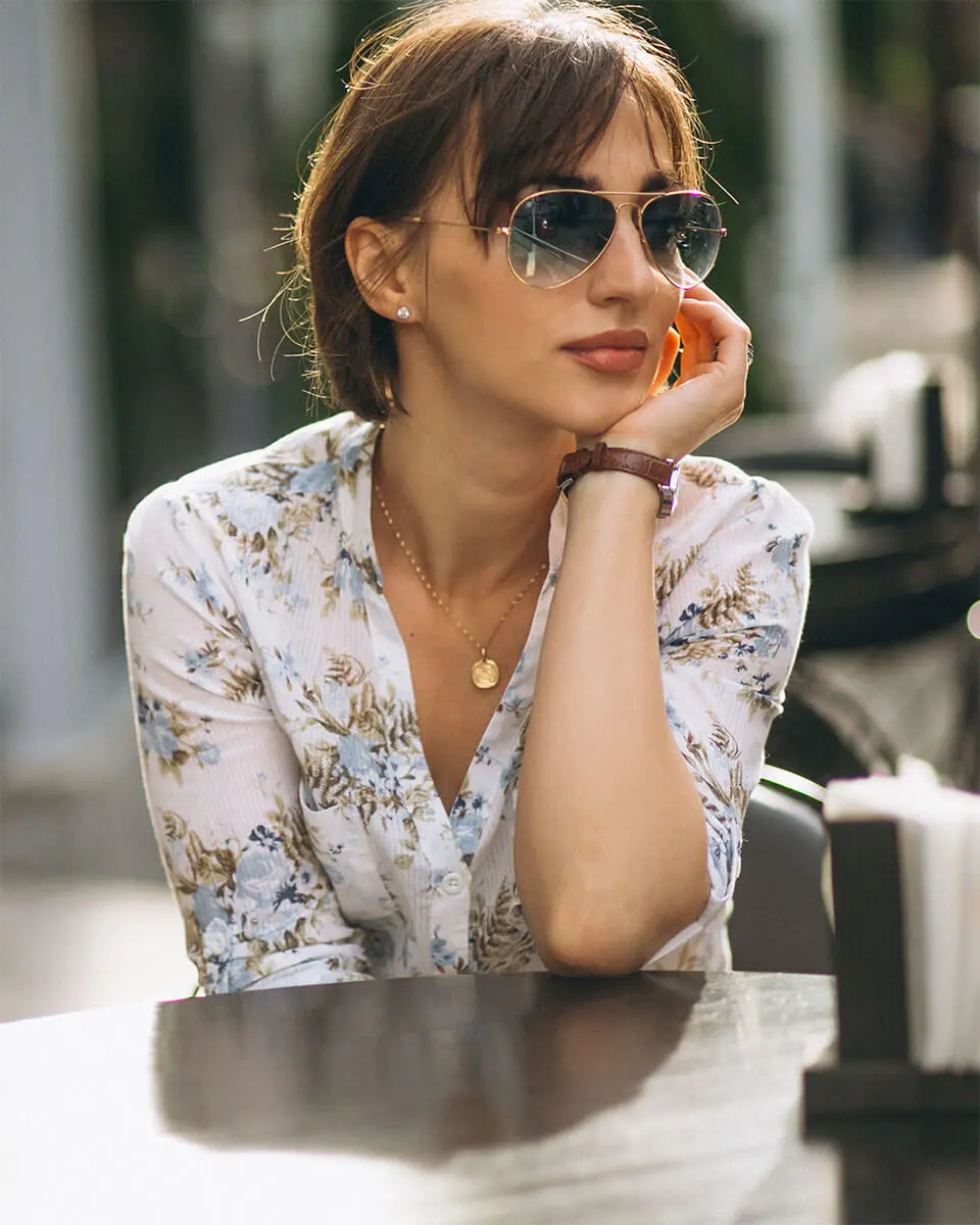 woman wearing glasses touching her face