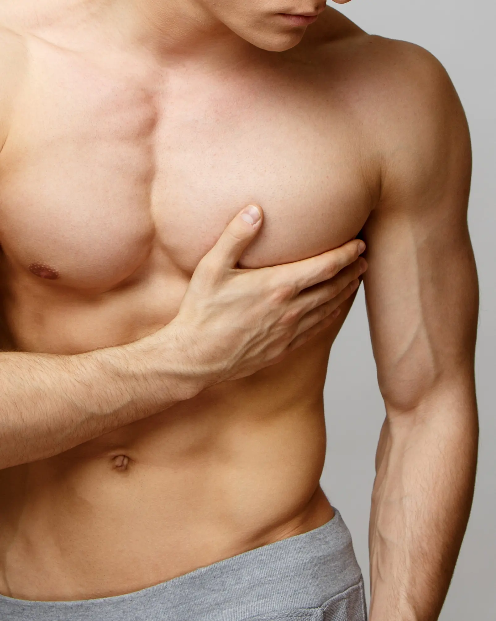 Shirtless man touching his chest
